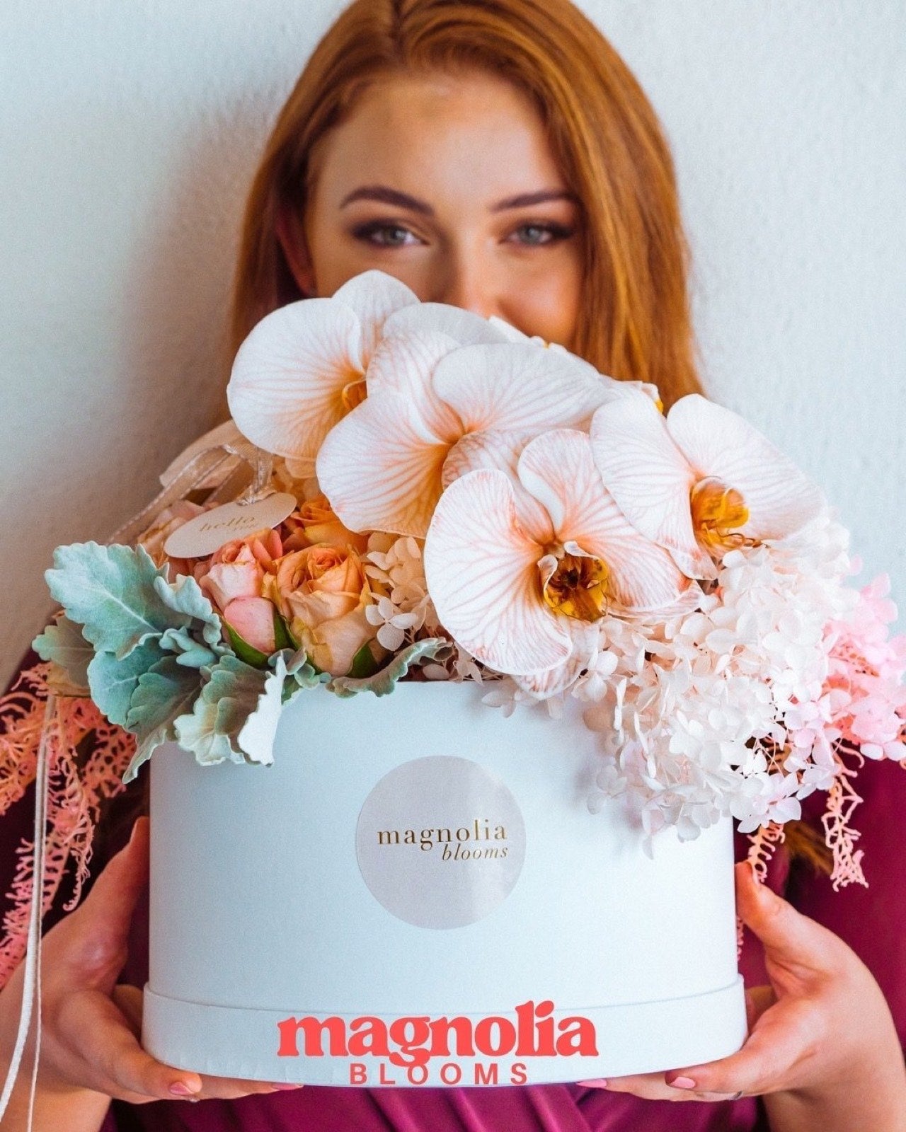 A Magnolia Blooms hat box filled with orchids and preserved blooms